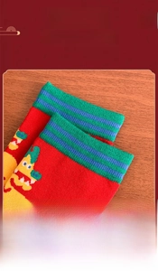 Detailed close-up of elastic striped cuffs and dragon embroidery on red cotton socks