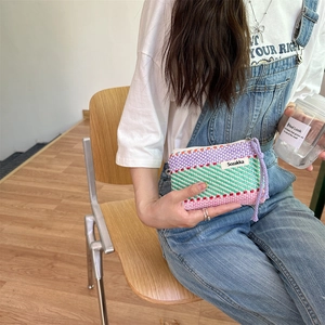 Close-up of a colorful woven makeup bag with vibrant stripes and high-quality zipper detail