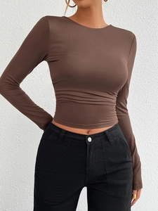 Detail view of brown slim fit long sleeve top with round neck and waist ruched texture