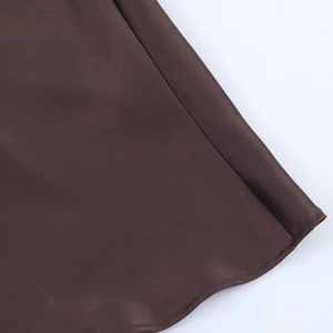 Detailed close-up showing the fine satin texture and stitching of the dark brown dress hem