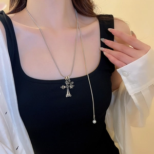 Dettaglio della collana a croce argento con diamanti neri e perla su modella