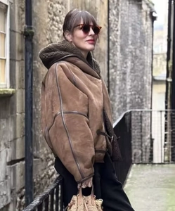 Dettaglio della giacca con cappuccio in pelle scamosciata marrone con fodera in shearling