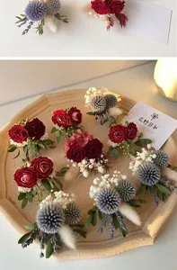 Close-up of handmade preserved flower corsages with roses on a ceramic tray