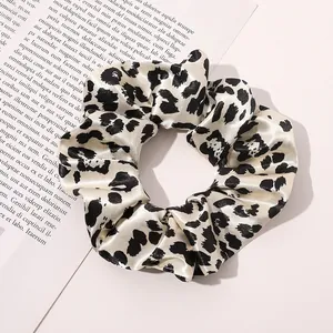 Close-up of leopard print silk scrunchie with satin texture on lifestyle magazine