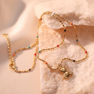 Gold teddy bear pendant necklace with colorful beads on a luxury silk and stone setting