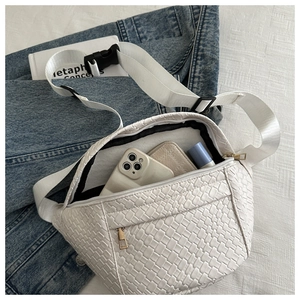 Detailed view of white woven waist bag showing internal capacity for phone and cosmetics