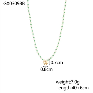 Detail of beaded necklace with green stones and a gold bow pendant including dimensions