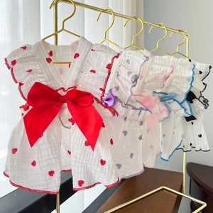 Detail of heart print pet dresses featuring large bows and ruffled gauze texture