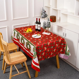 Nappe de Noël rouge avec couronnes festives et motifs de cloches sur une table de fête