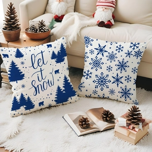 Detail showing two blue Christmas pillow covers on a soft rug with holiday decorations