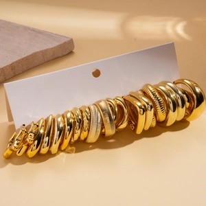 Detail of 20-piece gold geometric earring set including hoops and textured designs on card