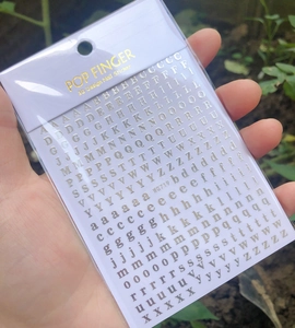 Detail view of WG719 gold 3D alphabet nail stickers with uppercase and lowercase letters