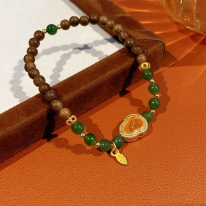 Detail of garnet jasper beaded bracelet with gold leaf and diamond-set Ruyi pendant