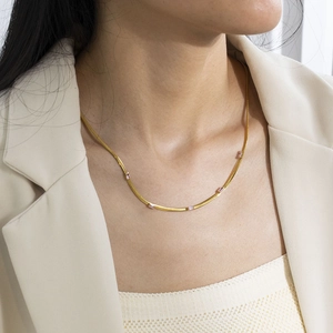 Detail of 18K gold plated necklace with pink rectangular zircons on female neck