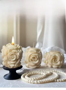 Détails des pétales de rose sculptés sur des bougies colonnes blanc cassé