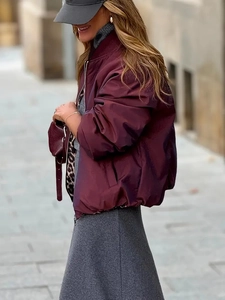 Close-up of burgundy reversible bomber jacket with leopard print lining and zipper