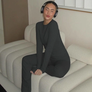 Detail of a slim fit black crew neck long sleeve top and flared pants set for loungewear