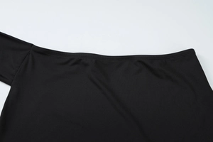 Macro detail of black asymmetric neckline with double-needle stitching on jersey fabric