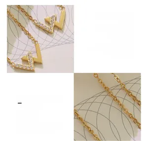 Makro-Detail einer 18K vergoldeten Halskette mit W-Buchstaben-Anhänger und Zirkon-Steinen