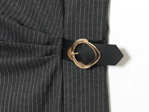 Detailed close-up of dark grey striped fabric with a gold buckle and black leather belt