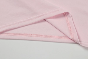 Macro detail of high-quality double-needle stitching on light pink knit dress hem