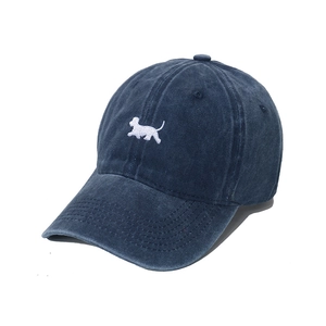 Detailed embroidery of a white puppy on a vintage washed navy blue baseball cap