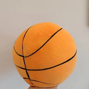 Close-up of soft plush basketball pillow showing detailed black stitching and velvet texture