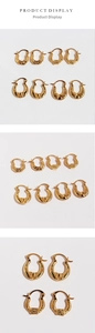 Detailed view of vintage gold U-shaped earrings with embossed patterns and textures