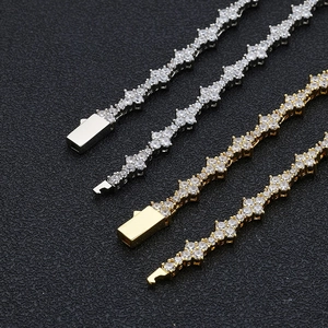 Hip hop zircon cross link bracelets in gold and silver finish on a textured black surface