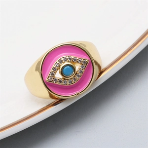 Macro shot of pink enamel evil eye ring with blue beads and white zircon stones