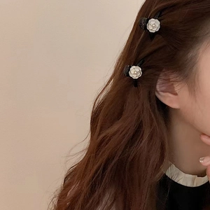 Mini camellia flower hair clips with pearls on model with long brown hair
