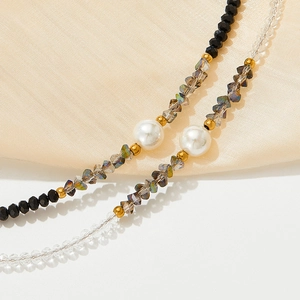 Elegant beaded bracelet featuring black crystals, clear gems, and a large white pearl