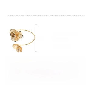 Détail du bracelet ouvert doré avec pétales évidés et cristaux étincelants