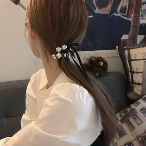 Élastique à cheveux élégant avec perles argentées et ruban noir porté en queue