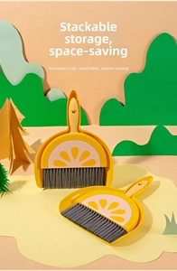 Close-up of a mini desktop broom and dustpan set with a cute yellow fruit pattern design