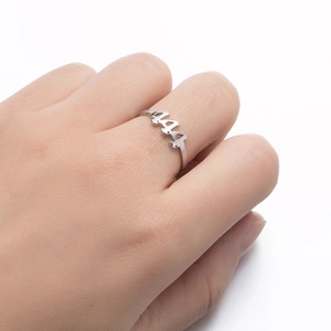 Detail of silver stainless steel ring featuring cut-out 444 angel number design on hand