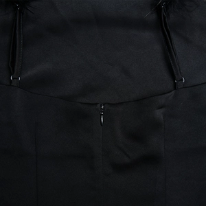 Détail du dos de la robe en satin noir avec bretelle en plumes et fermeture éclair invisible