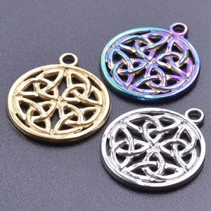 Détail macro de pendentifs nœud celtique en or, argent et acier arc-en-ciel poli