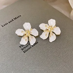 Elegant floral stud earrings with pearl white silk texture and gold-plated diamond accents
