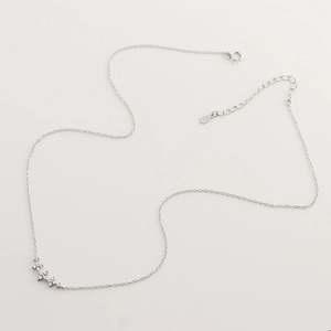 Detailed macro view of S925 sterling silver chain with tiny clover diamond pendants
