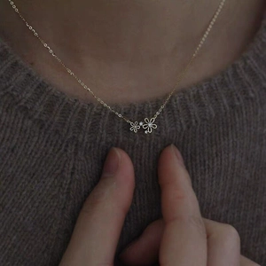 S925 sterling silver 14K gold plated necklace with two delicate floral pendants on a model
