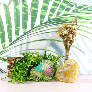 Detail of striped heart-shaped resin storage box and ornament with sunlit plant shadows