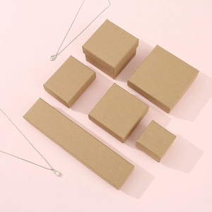 Various sizes of kraft paper jewelry boxes for rings and necklaces on pink background