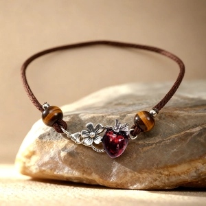 Tiger eye stone bracelet with red strawberry and silver flower on brown woven cord