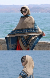 Détail d'un châle à capuche avec motifs géométriques marron et bleu et bords frangés
