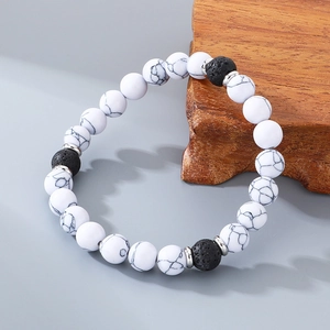 Detailed macro shot of white turquoise beads and black lava stones on elastic bracelet