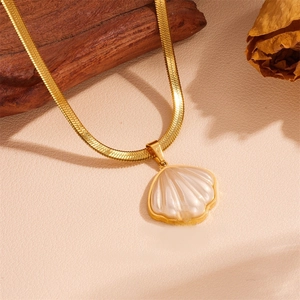Detailed macro view of the gold-plated shell pendant with a flat snake bone chain