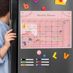 Action shot of writing on a pink magnetic acrylic monthly planner on a refrigerator door