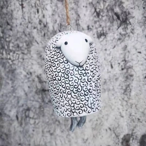 Detail of handmade resin sheep wind chime with black swirl patterns and natural jute rope