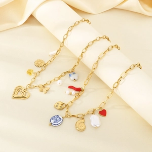 Detailed shot of golden charm bracelets with heart, flower, and butterfly charms on silk